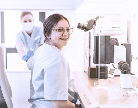 Employee in front of the microscope Employee in front of the microscope